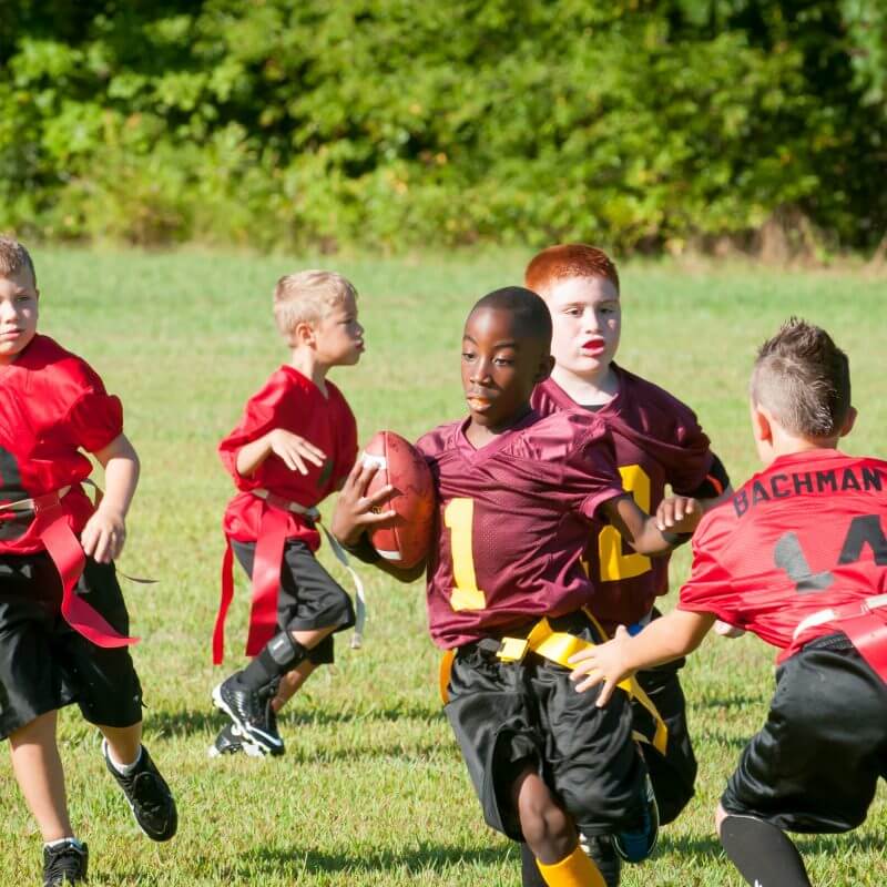 Eine Gruppe von Kindern beim American Football spielen