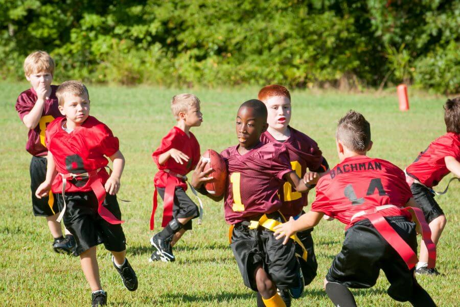Eine Gruppe von Kindern beim American Football spielen