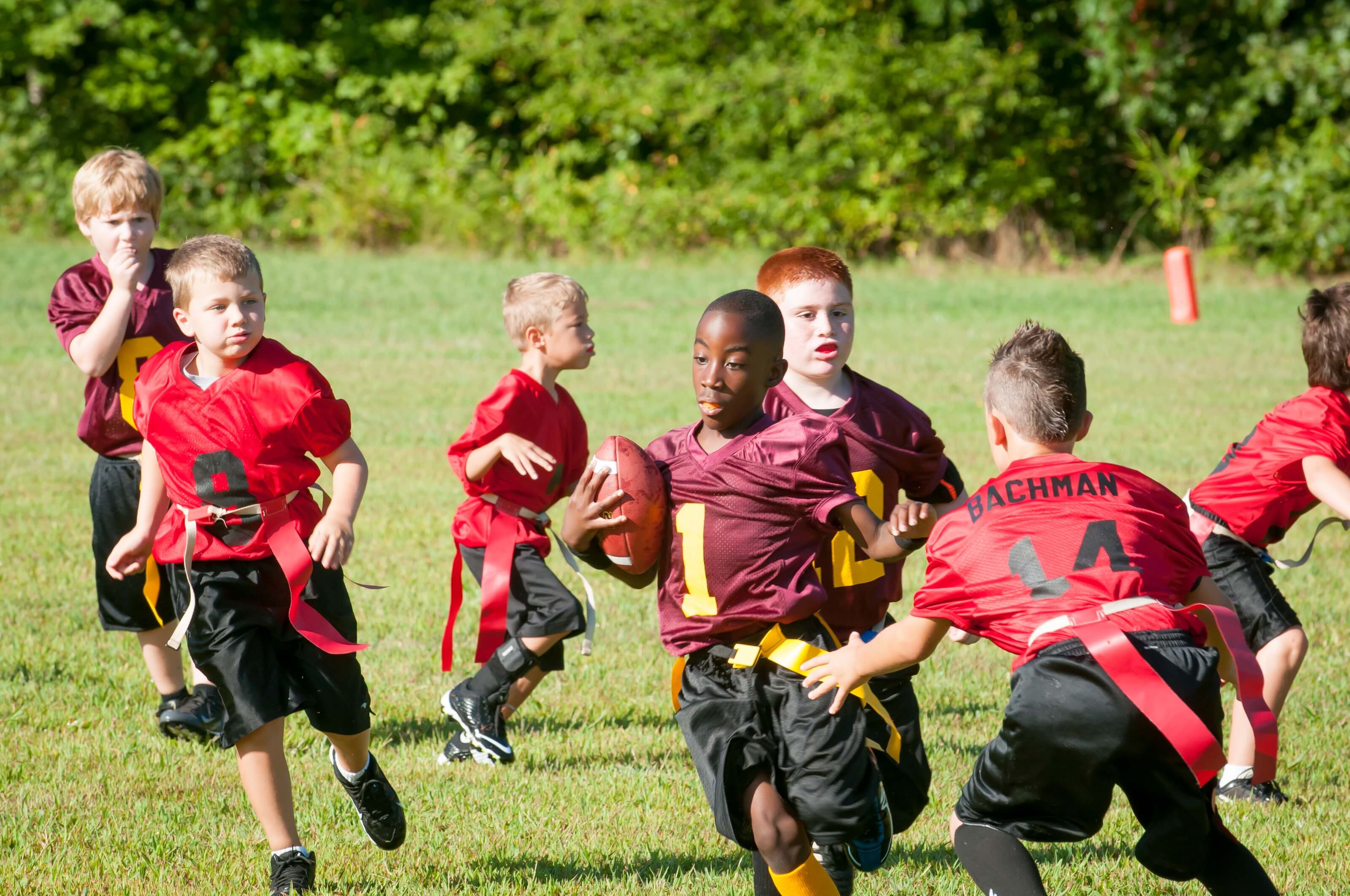 Eine Gruppe von Kindern beim American Football spielen