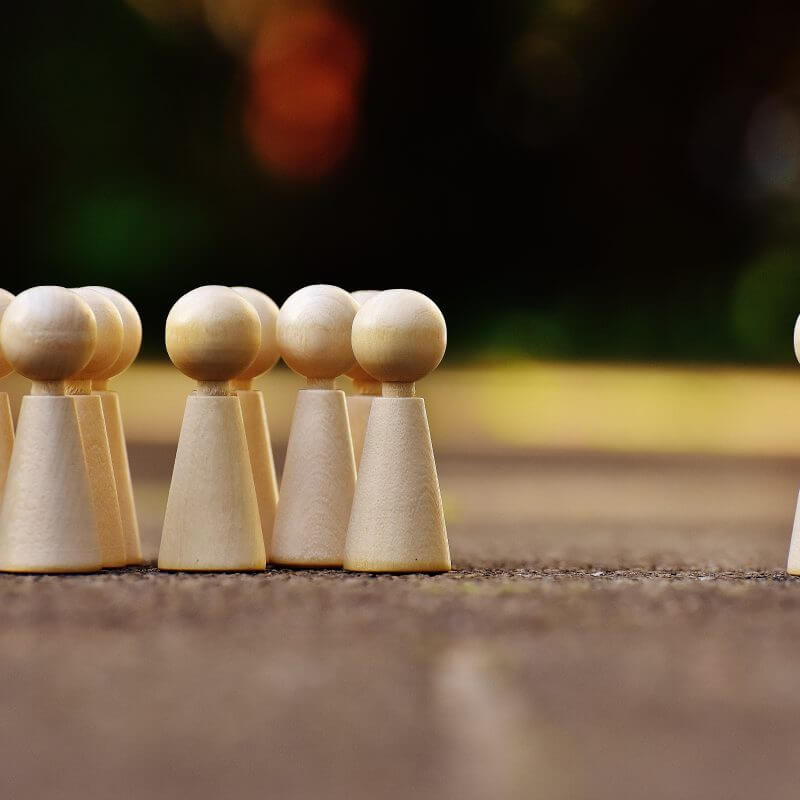 Spielfiguren als Gruppe stehen neben einer einzelnen Spielfigur