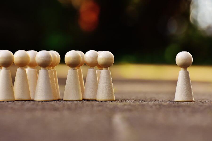 Spielfiguren als Gruppe stehen neben einer einzelnen Spielfigur