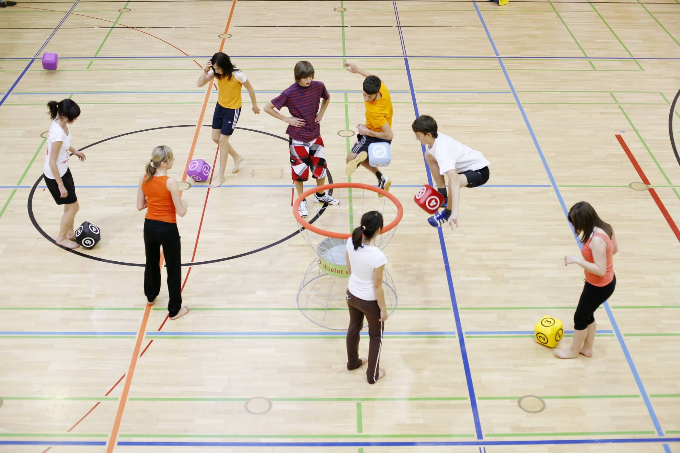 Eine Gruppe von Kindern spielt Fußball mit Würfeln in einer Turnhalle