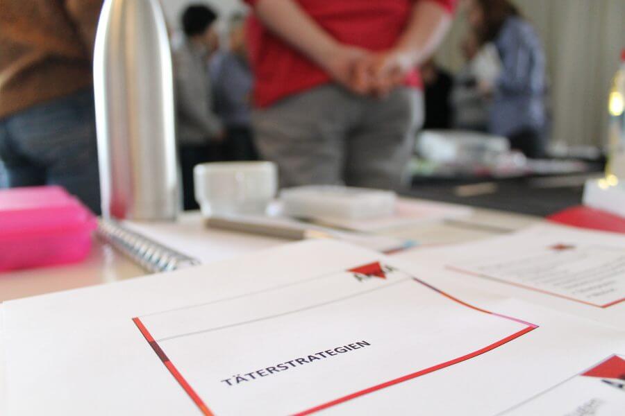 Auf einem Tisch liegt ein Zettel mit der Aufschrift Täterstrategien