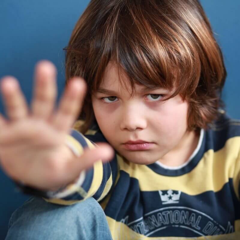 Ein Kind sitzt auf dem Boden und streckt den Arm aus