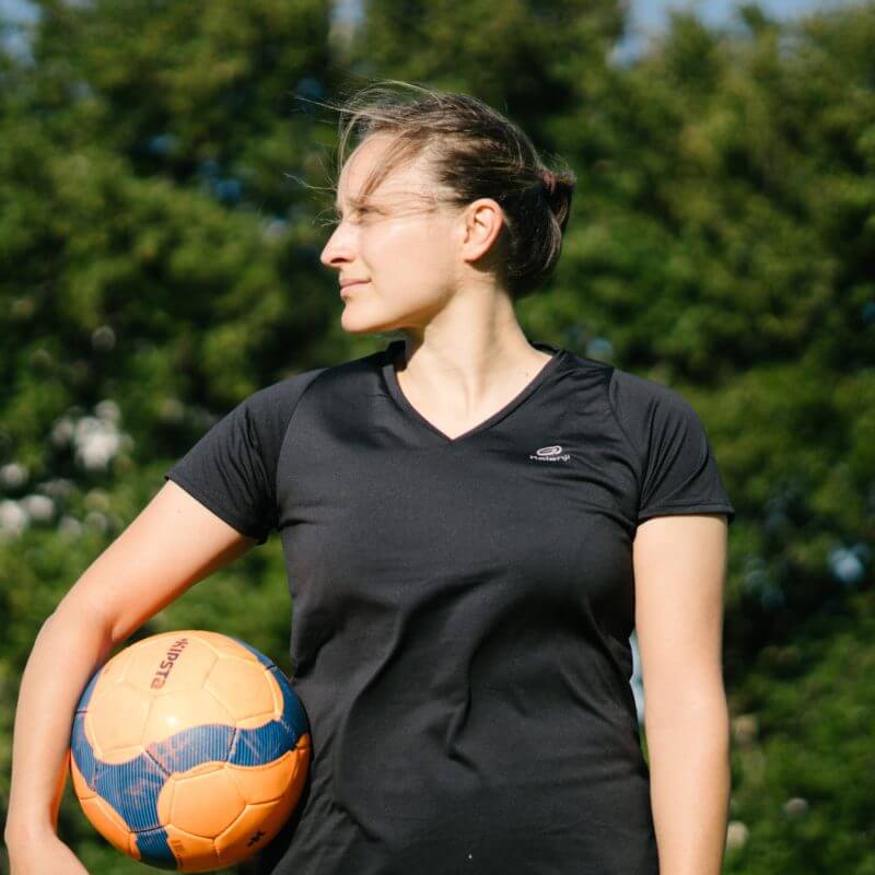 Eine Frau mit einem Fußball unter dem Arm