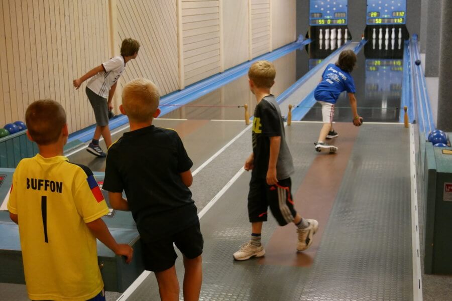 fünf Kinder auf einer Kegelbahn