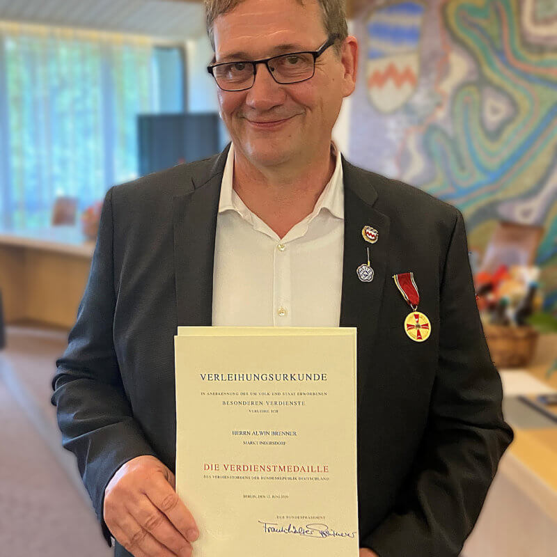 Ein Mann hält eine Urkunde vor der Brust