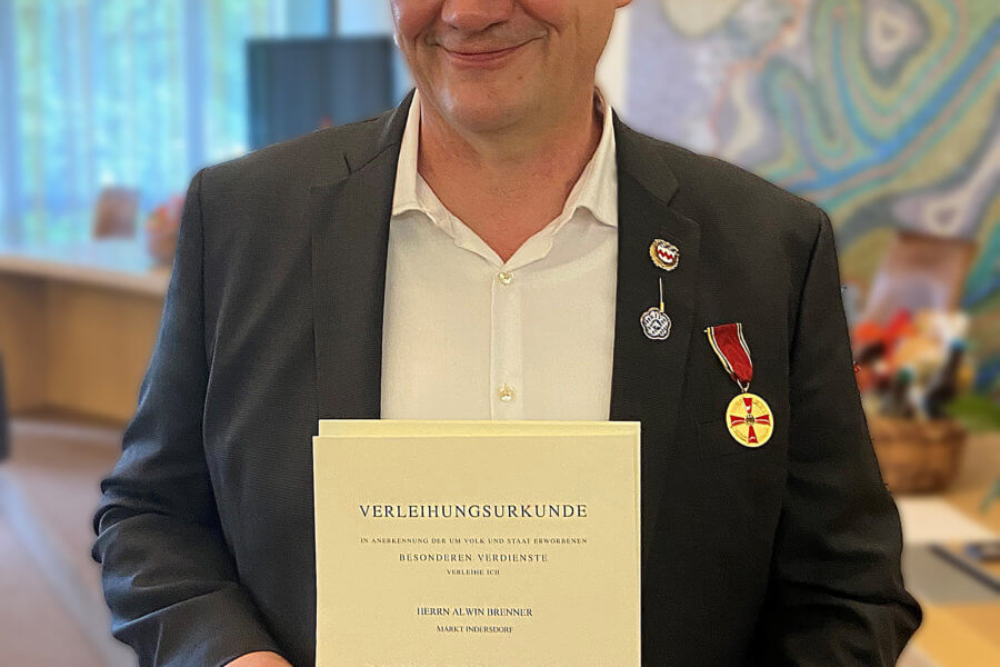 Ein Mann hält eine Urkunde vor der Brust