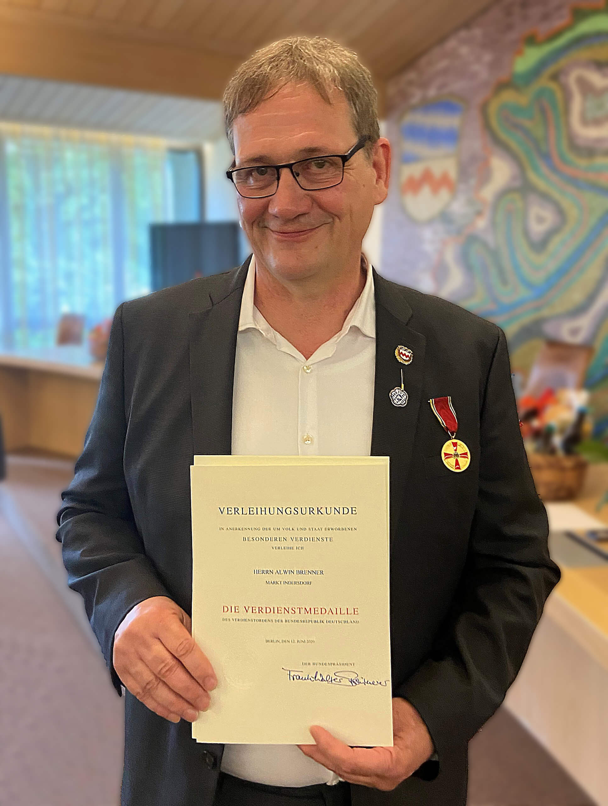 Ein Mann hält eine Urkunde vor der Brust