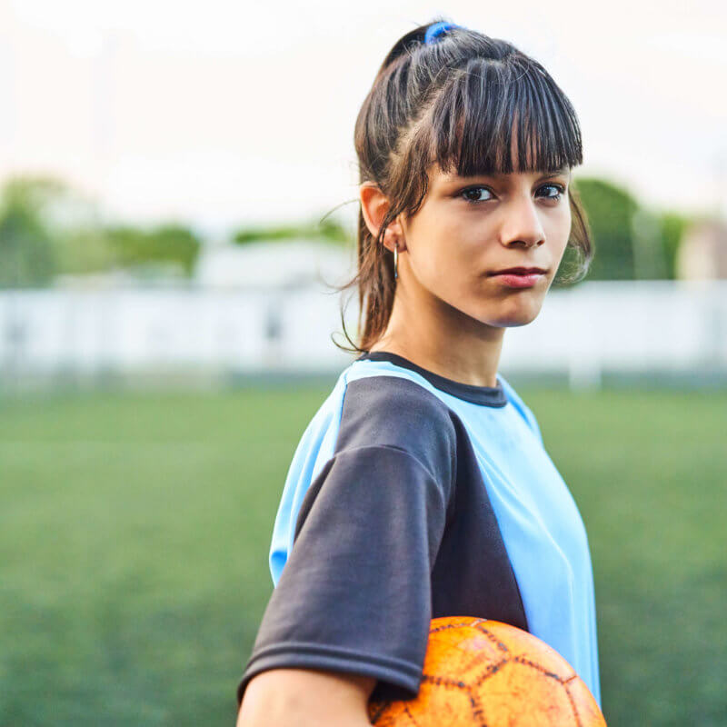 Eine Frau mit einem Ball unter dem Arm