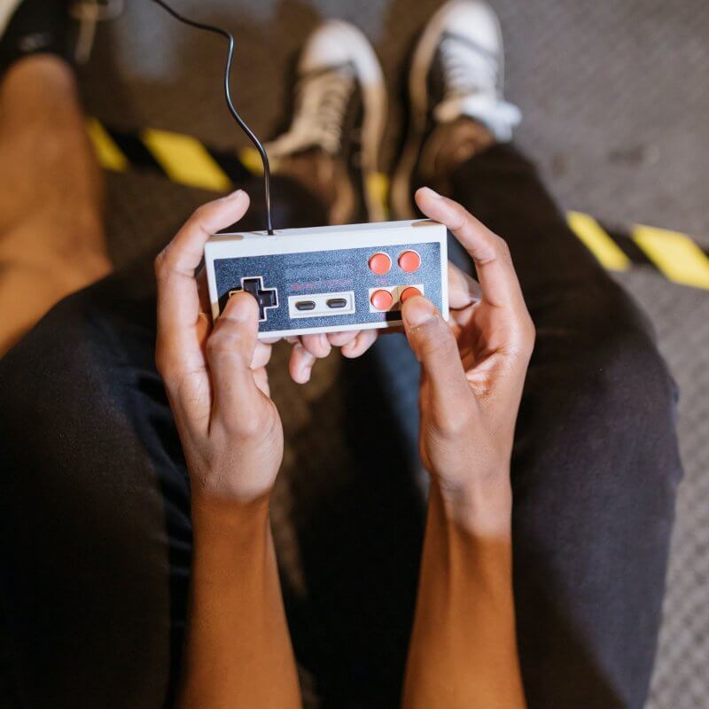Zwei Hände bedienen einen Retro-Spielecontroller