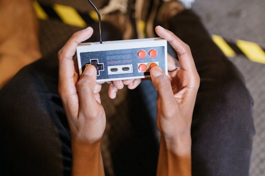 Zwei Hände bedienen einen Retro-Spielecontroller