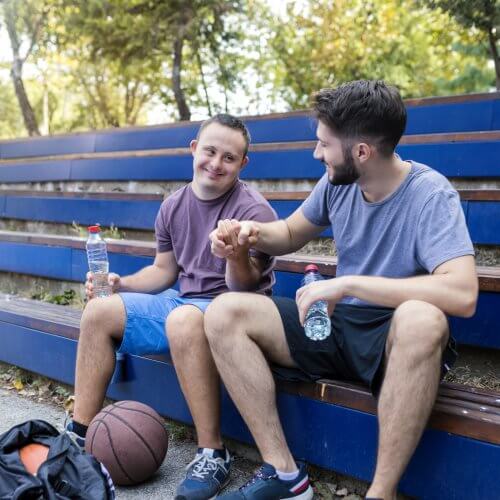Zwei Männer sitzen auf einer Tribüne und machen Pause