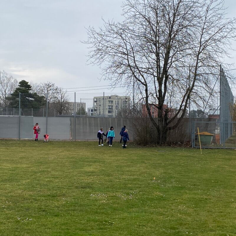 Kinder spielen rund um die Eckfahne eines Fußballplatzes