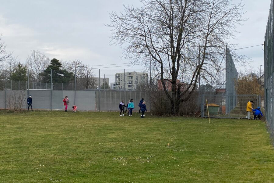 Kinder spielen rund um die Eckfahne eines Fußballplatzes