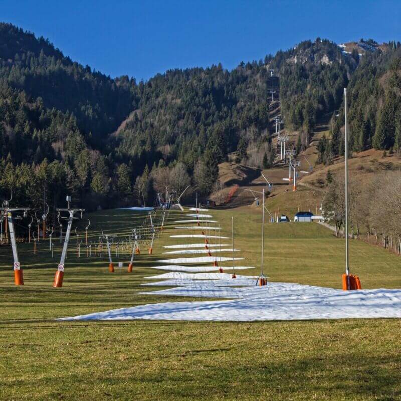 Eine Skipiste im Sommer mit wenigen Schneeresten