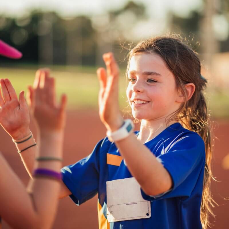 Zwei Mädchen auf einem Sportplatz klatchen ab