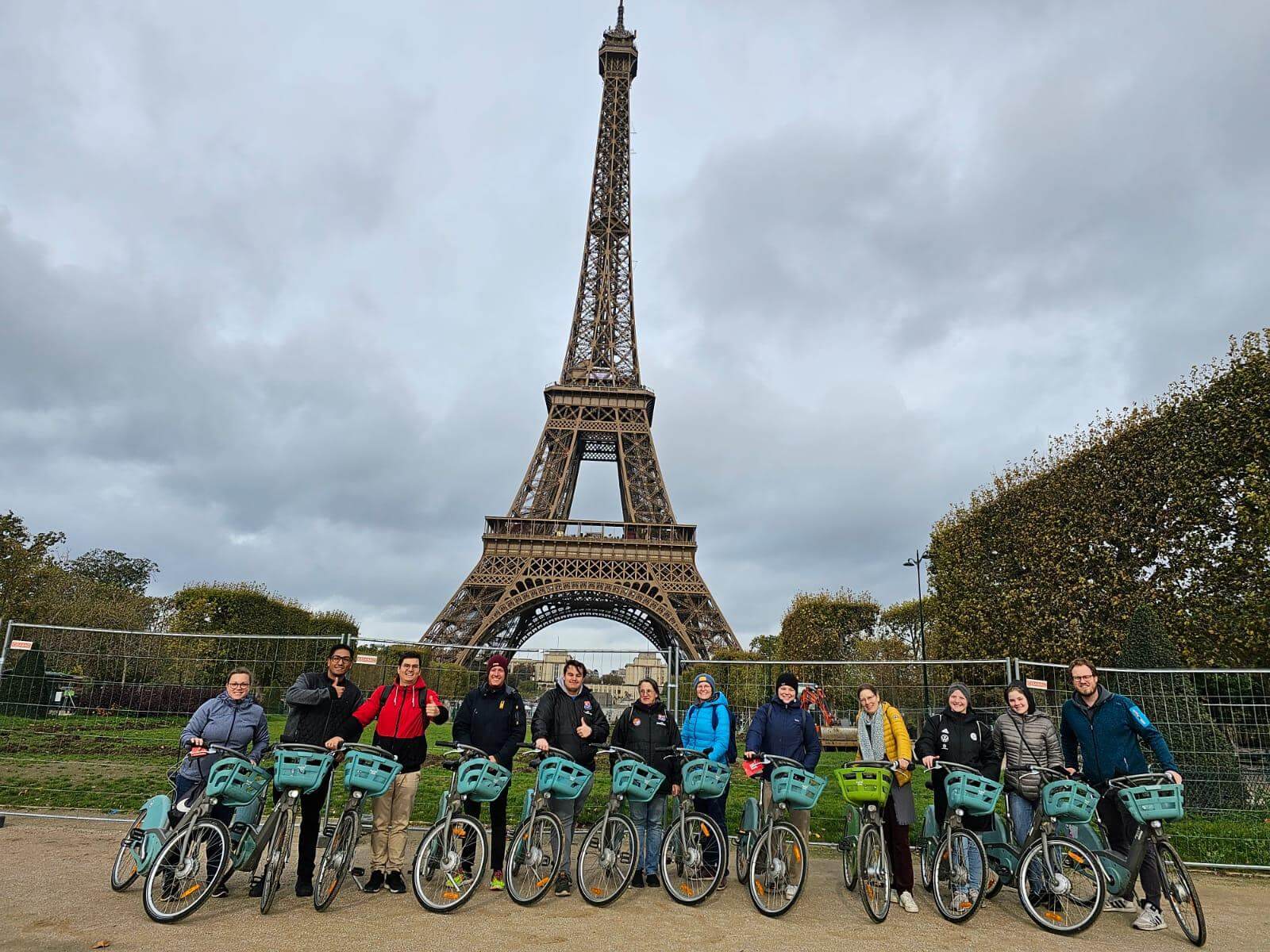 Eine Gruppe von Menschen auf Fahrrädern. Im Hintergrund der Eifelturm