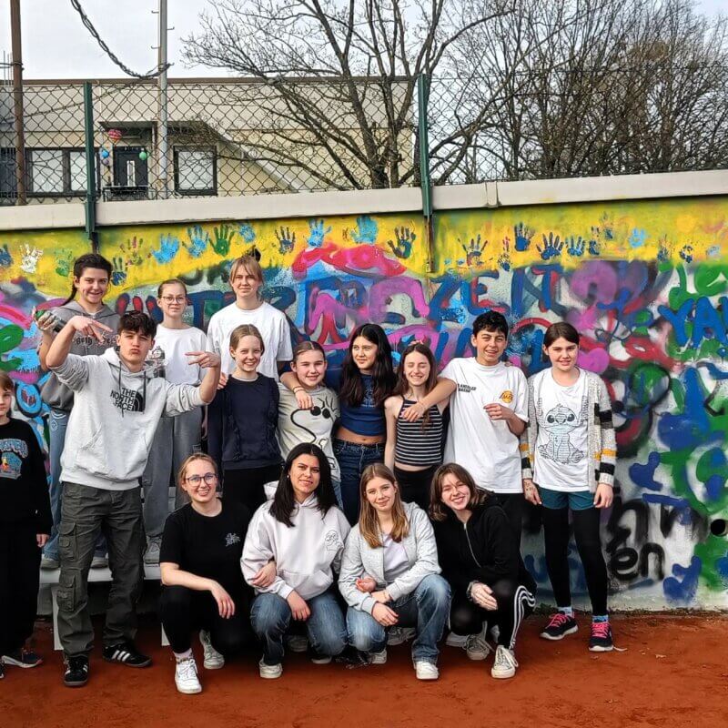 Jugendliche stehen vor einer Grafitti-Wand