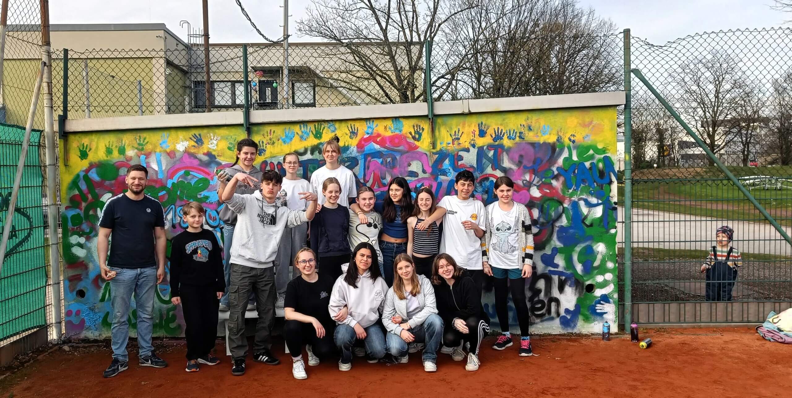 Jugendliche stehen vor einer Grafitti-Wand