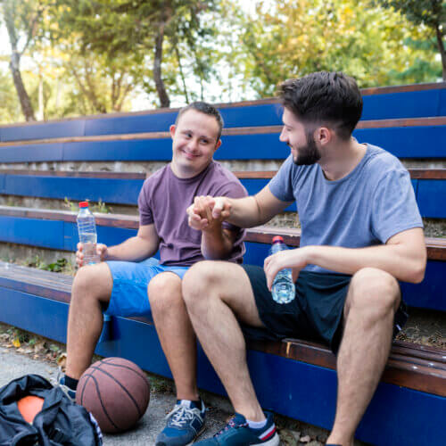 2 Männer sitzen auf einer Tribüne und machen Pause