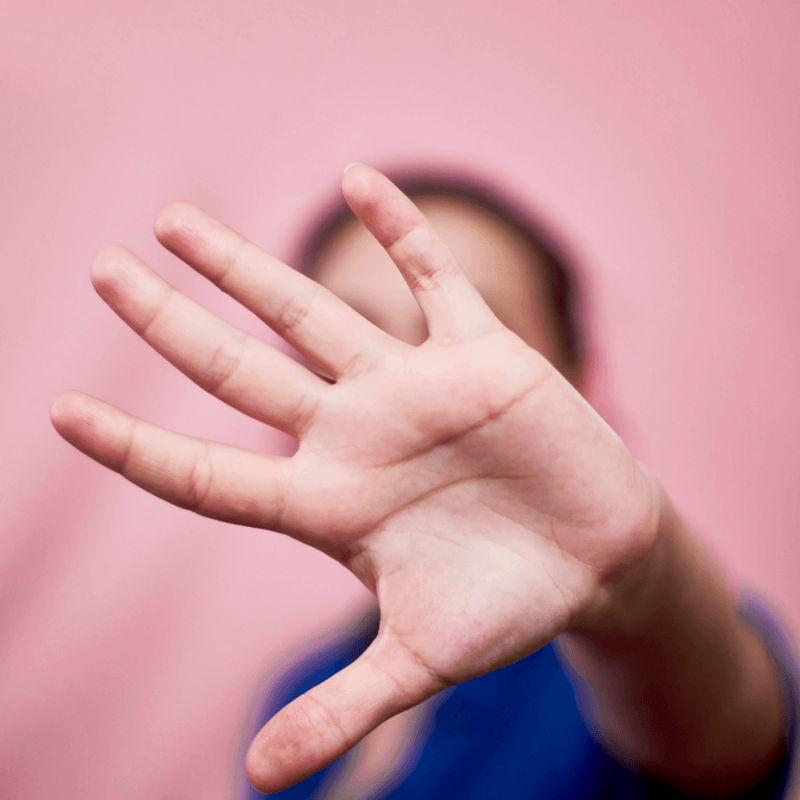 Eine Person streckt ihre Hand in die Kamera. Damit soll ein Stopp signalisiert werden