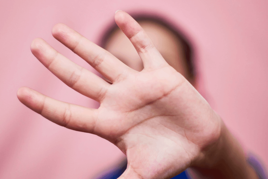 Eine Person streckt ihre Hand in die Kamera. Damit soll ein Stopp signalisiert werden