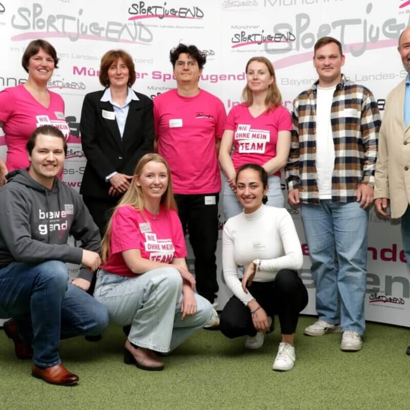 Eine Gruppe von Menschen vor einem Werbebanner der MSJ